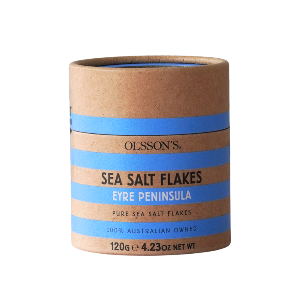 A cylindrical cardboard container of Olsson's Sea Salt Flakes Eyre Peninsula, 120g, featuring a kraft brown paper body with blue and white striped labels.