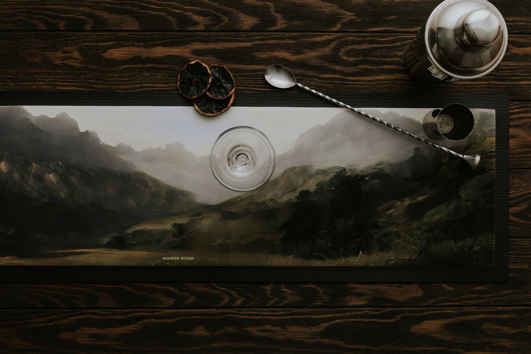 Large rubber backed bar mat by Manor Road with a landscape mountain image. With cocktail shaker and stirrer. 