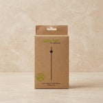 A brown kraft paper box for a 12cm Kasari kushi skewer by Green Bean Eco-Blowstacks, standing upright on a light beige textured surface.