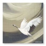 A paper napkin depicting a white crane in flight against a soft, abstract background of muted beige, gray, and dark charcoal tones. The text 'MANOR ROAD' is printed in the bottom right corner.