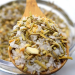 Wooden spoon filled with a mixture of herbs and spices over a blurred background
