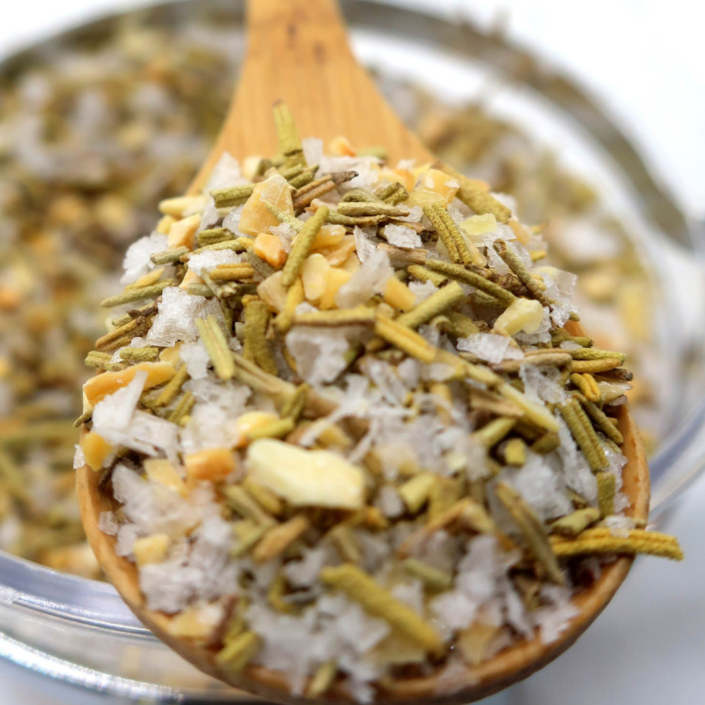 Wooden spoon filled with a mixture of herbs and spices over a blurred background