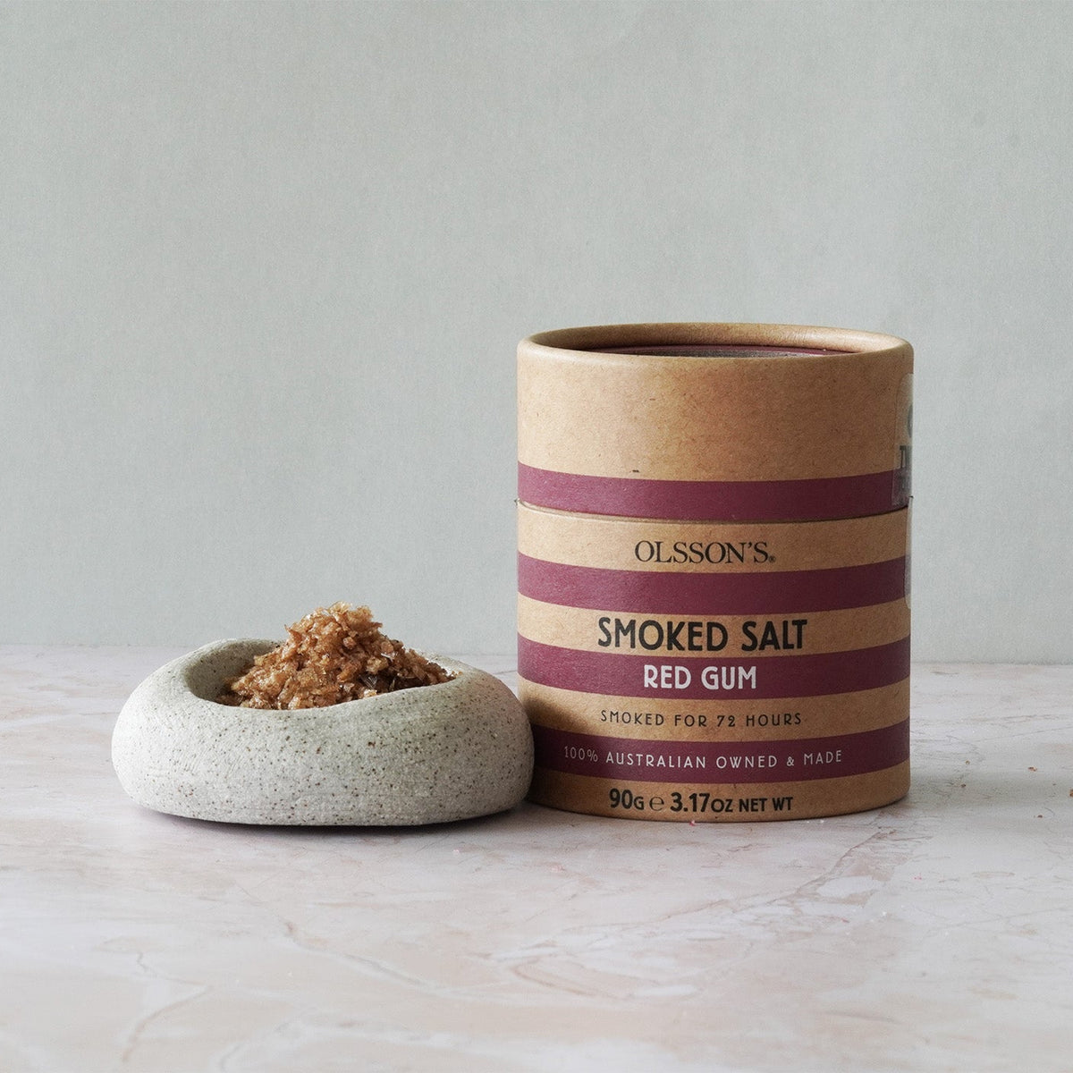 Container of Olsson's Smoked Salt Red Gum on a light surface with a neutral background