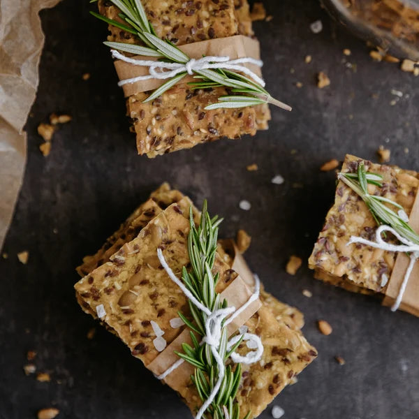 Cracker squares with rosemary tied with string on a dark surface