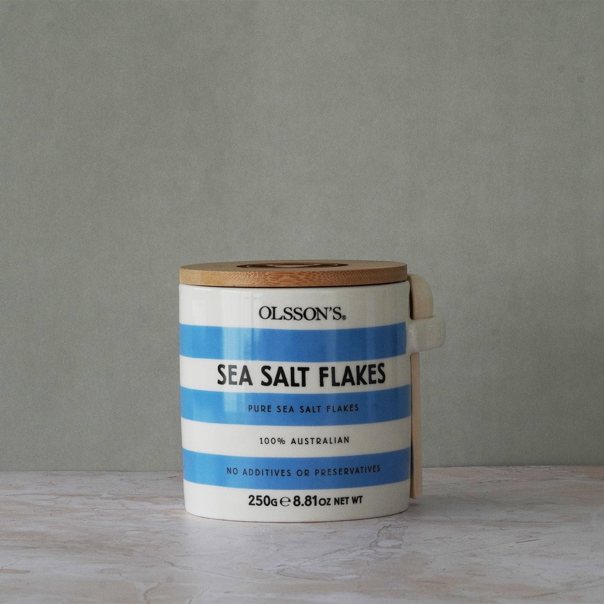 Container of Olsson's Sea Salt Flakes on a gray background