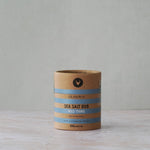 Cardboard container of Olsson's Sea Salt Rub on a wooden surface with a gray background